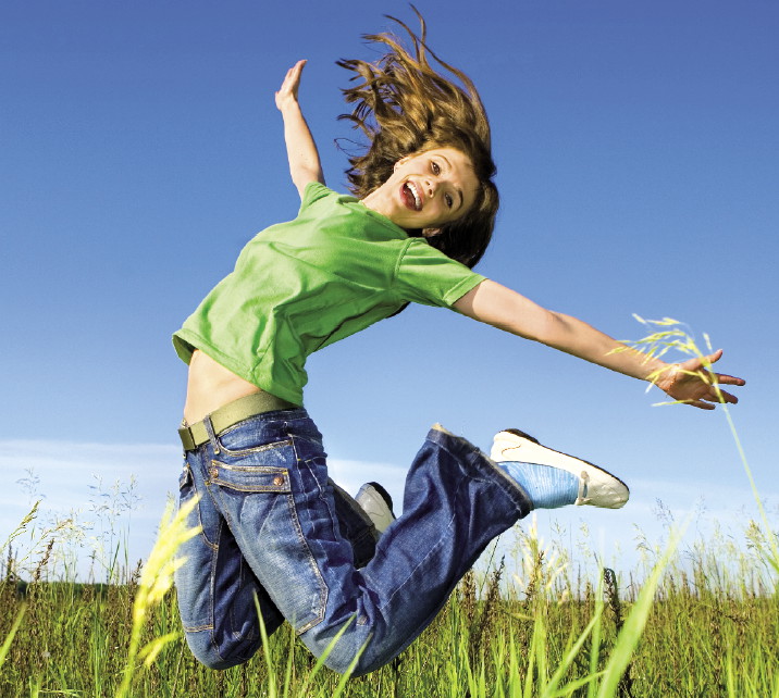 Девушка в прыжке на поле с хорошим настроением