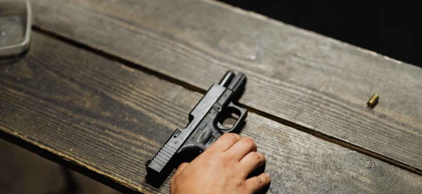 hand of a person holding black semi automatic pistol