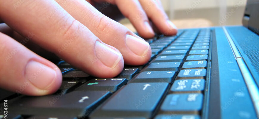 computer keyboard with human hand close-up